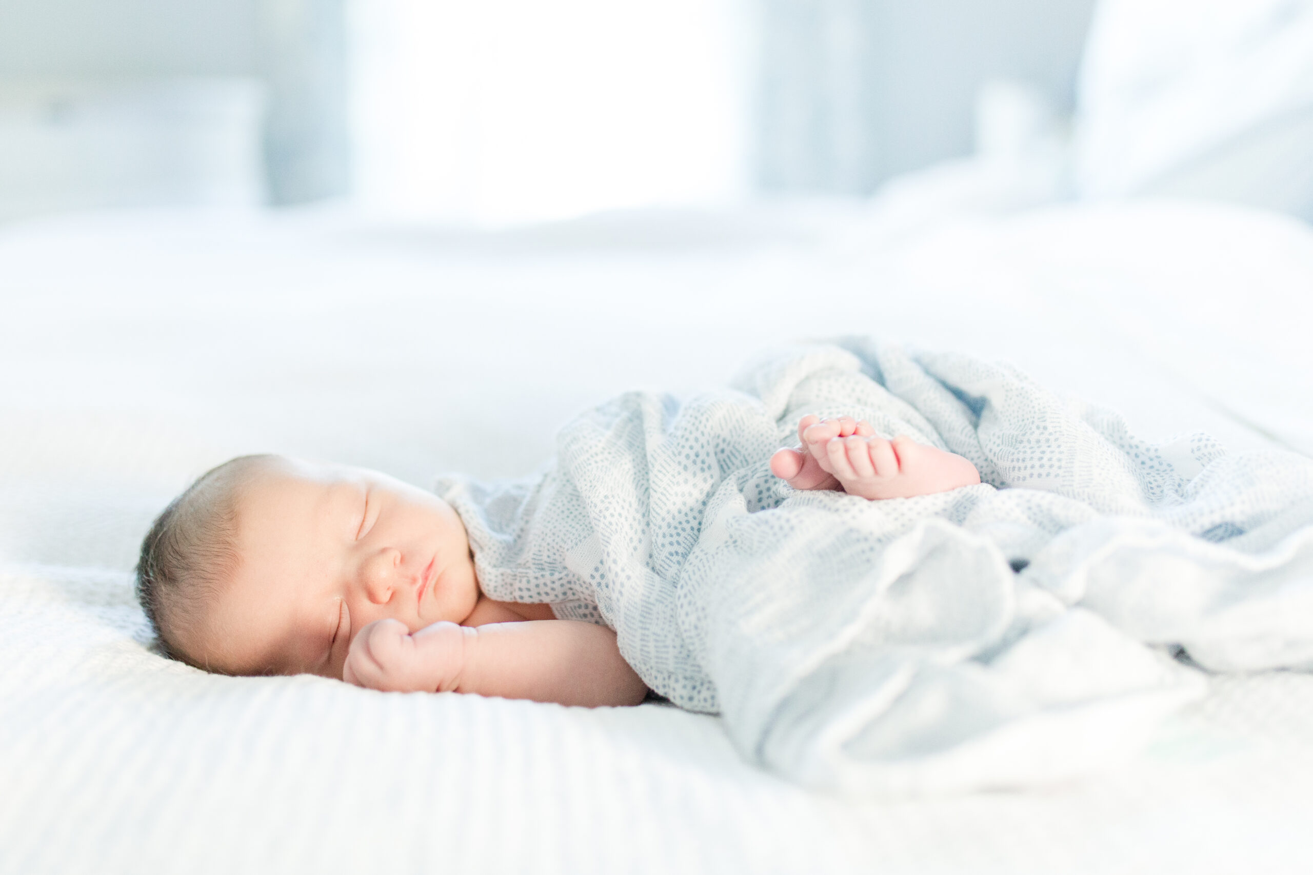 Newborn Baby lying on a bed