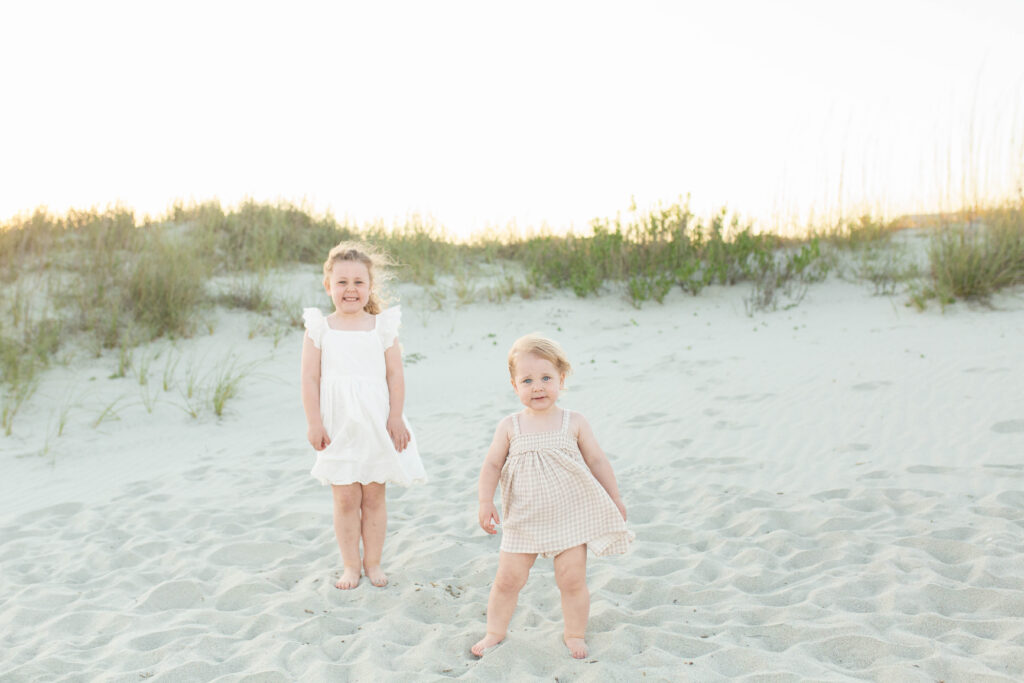 Candid shot of young sisters on the beach during an extended family session