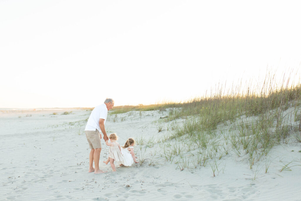 candid shot of a grandfather walking with his granddaughters