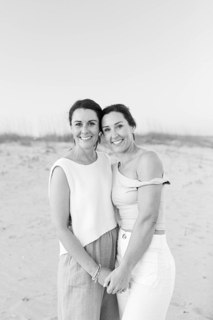 Adult sisters on the beach at sunset